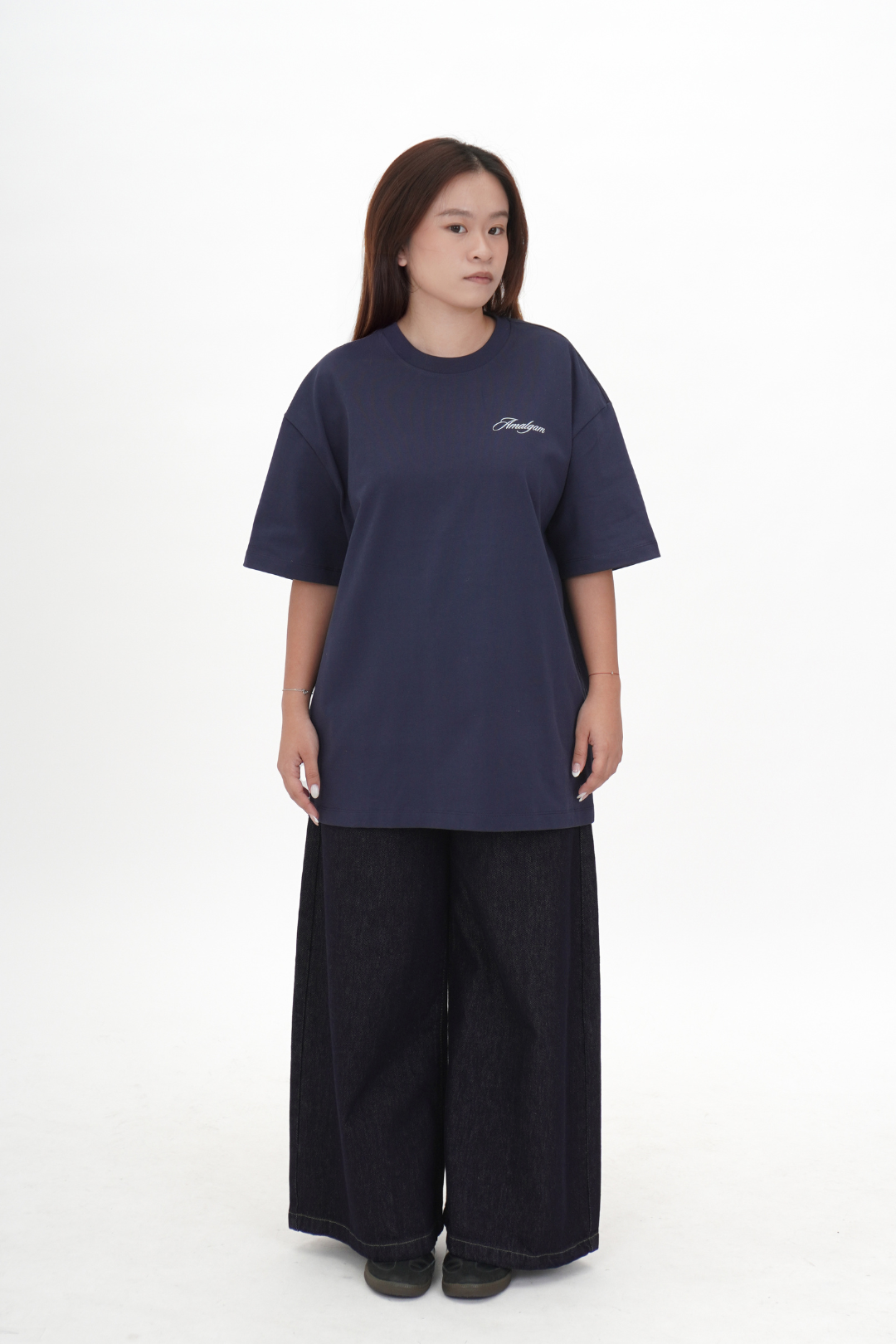 Person wearing a navy blue t-shirt with a logo on a white background Navy Blue Amalgam Overdrive Graphic Tee Oversized