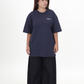 Person wearing a navy blue t-shirt with a logo on a white background Navy Blue Amalgam Overdrive Graphic Tee Oversized