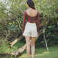 Red maroon curve design top on the front and back with curve bare back detail crop top long sleeve made from soft cotton and tailored pearl white colour shorts design with structure to fit made from cotton 